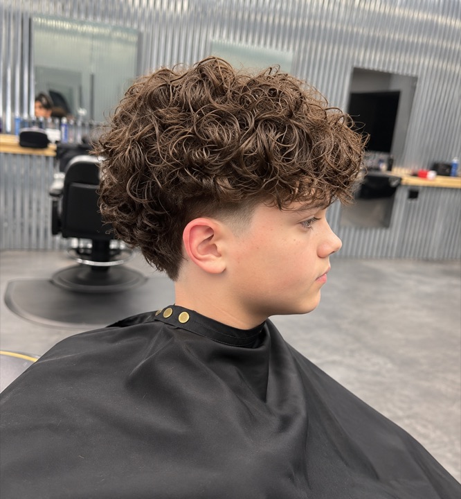 Curly brown haircut with tapered sides — AI-retouched image